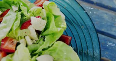 Kamera taze salata dokusunu ön plana çıkarırken altıgen ızgaralar soluyor, mavi cam kasenin üzerinde sürükleniyor. Taze ürün, dijital büyütme, kırsal dekor, sağlık bilinci, modern estetik, canlı renkler, organik