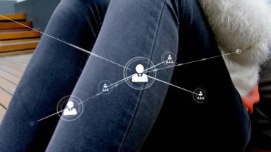 Güvertede akıllı telefonu dinleyen bir kadın sosyal ağı gözünde canlandırıyor kot pantolon ve kazak üzerinden genişliyor. Dijital, bağlantı, modern, sosyal, gündelik, canlı, teknolojik