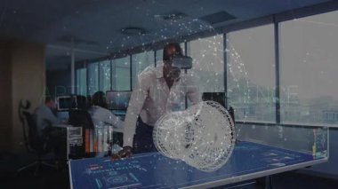 Olgun bir adam VR kulaklığı yerleştiriyor ve dijital masadaki analiz için 3 boyutlu küreyi silindire dönüştürüyor. Teknoloji, işbirliği, yenilik, fütüristik, çalışma alanı, veri, görselleştirme