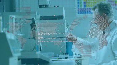 Kıdemli bilim adamı, dünya haritası veri örtüsünü izlerken test etmek için numuneyi analiz cihazına yüklüyor. Araştırma, yenilik, teknoloji, veri, analiz, bilimsel, laboratuvar