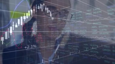 Kadın yönetici, piyasa görüşleri için canlandırılmış şamdan çizelgelerini takip ederken tablete bakıyor. İş, finans, teknoloji, analitik, şirket, yatırım, dijital