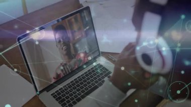 Masada kulaklıklarını indiren bir adam, iletişim ağıyla bir kadına el sallayan bir teknik çağrı başlatıyor. Teknoloji, iletişim, uzaktan çalışma, dijital, ağ, işbirliği, modern