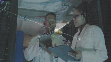 Mühendisler veri merkezindeki tableti tıklayarak ağ çizgilerine genişleyen parlayan düğümleri analiz ediyorlar. Teknoloji, yenilik, bağlantı, işbirliği, fütüristik, analitik, devre