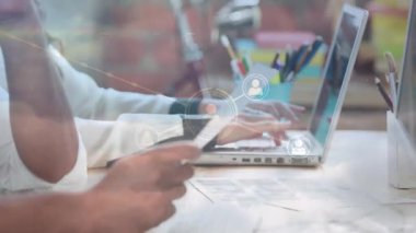 İş arkadaşları ellerinde kağıt tutarak dizüstü bilgisayar yazıyorlar ve genişleyen kullanıcı profili simgeleri oluşturuyorlar. İşbirliği, takım çalışması, dijital, teknoloji, ağ oluşturma, yenilik, modern