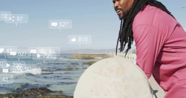 Okyanusa dayanan orta yaşlı bir adam etrafında büyüyen sosyal medya simgelerini başlatıyor. Deniz kenarı, tefekkür, dijital, dinginlik, bağlantı, manzara, modern