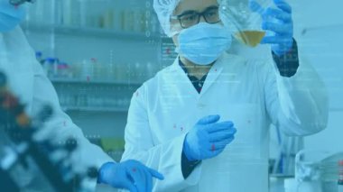 Kadın bilim adamı numuneyi mataraya yerleştiriyor ve erkek bilim adamı laboratuvarda kehribar çözeltisini inceliyor. Araştırma, işbirliği, analitik, kesinlik, yenilik, bilimsel, teknoloji