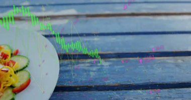 Yakın plan kamera, salata tabağını grafikte dalgalanan piyasa eğilimlerinin üzerinde gösteriyor. Kırsal, sağlıklı, dijital, analitik, taze, canlı, aşçı