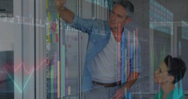 İşbirlikçi meslektaşlar, ofiste cam bölme ve çizelgeler ile yapışkan notlar işaretliyor. Ofis, takım çalışması, yenilik, dijital, analitik, strateji, modern