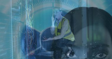 Akıllı telefonu tutan diz çökmüş bilişim teknolojisi veri merkezindeki sunucu rafı kablolarını HUD kaplamalı olarak açıklıyor. Ağ, teknoloji, işbirliği, dijital, bağlantı, endüstriyel, profesyonel