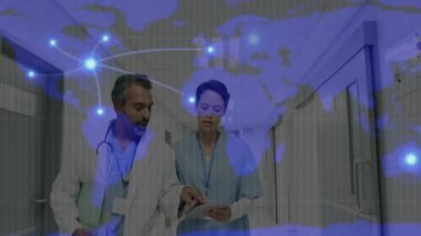 Tıbbi ekip koridorda yürüyor, verileri inceliyor, tablet tıkırtıları harita üzerinde titreşimlere neden oluyor. Sağlık, dijital, işbirliği, teknoloji, yenilik, profesyonel, bağlantı