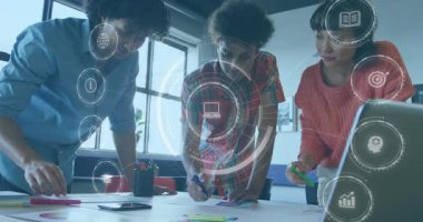 Meslektaşlar pembe keçeli kalem alıyor, diyagramın altını çiziyor ve proje planı için dijital simgeler oluşturuyorlar. İşbirliği, beyin fırtınası, yenilik, takım çalışması, planlama, dijitalleştirme, yaratıcılık