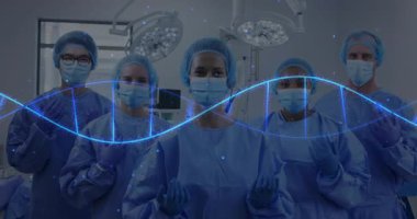 Cerrahi ekip ışıkların altında mavi dalgalı solla ayakta duruyor. Hastanın hayati belirtilerini gösteriyor. Tıbbi, sağlık, klinik, takım çalışması, yenilik, teknoloji, kesinlik