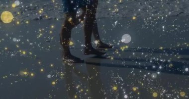 Çift ıslak kuma basıyor ve sahil yolculuğunda terfi için ışıltılı bir şekilde kıyı şeridinde yürüyor. Plaj, kıyı şeridi, yansıma, huzur, uyum, sükunet, minimalist