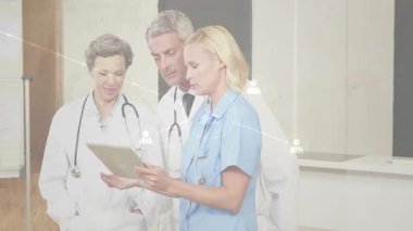 Hemşire tableti tıkırdatıyor. Hasta verilerini gözden geçiriyorlar. Doktorlar ikon ağıyla ilgili kayıtları gösteriyorlar. Sağlık, işbirliği, teknoloji, tıbbi ekip, dijital arayüz, tanı, profesyonel