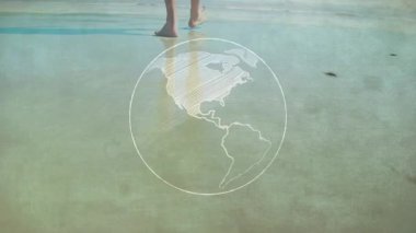 Yakın plan çekimde, bacaklar suya girerken, dünya kıtaları ve dalgalar ayak bileklerini yıkarken görülüyor. Deniz manzarası, seyahat şehveti, keşif, dinginlik, minimalizm, seyahat, doğa