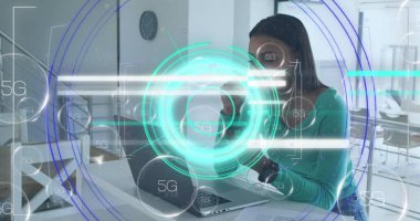 Elinde kupa, açık planlı ofiste gümüş dizüstü bilgisayarda yazan, 5G arayüzlü yetişkin bir kadın. Teknoloji, bağlantı, modern, çalışma alanı, profesyonel, yenilik, dijital