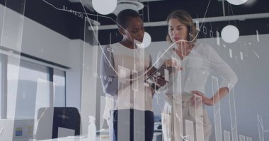 Ofis kıyafeti giyen meslektaşlar, el bilgisayarı üzerindeki verileri analiz ediyorlar. Profesyonel, takım çalışması, analitik, çağdaş, iş, işbirliği, üretkenlik