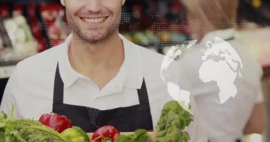 Elinde sandık tutan erkek bakkal kasası aktif olan nokta haritası dönen bir kürede kayboluyor. Kaynağı gösteriyor. Taze üretim, takım çalışması, perakende, sürdürülebilirlik, organik, canlı, profesyonellik