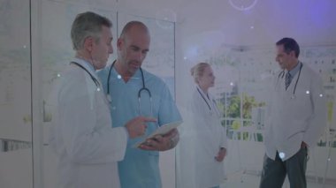 Hemşire tıp ekibine katılarak koridorda sürüklenen verilerle birlikte hasta verilerini gözden geçiriyor. Hastane, sağlık, takım çalışması, dijital, teknoloji, işbirliği, profesyonel