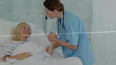 Hemşire hasta elini sıktı ve hastane yatağının üzerine eğilip serum altında rahatlatıcı bakım önerdi. Şefkat, destek, sağlık, profesyonellik, empati, tıbbi, güven