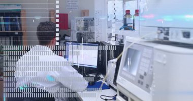 Laboratuvar teknisyeni laboratuvar önlüğü giyip laboratuvar bankındaki çift monitörlerin verilerini analiz ediyor. Bilim adamı, araştırma, teknoloji, kesinlik, yenilik, analiz, ekipman