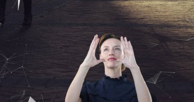 Koyu renk bluz giyen bir kadın stüdyoda elleri ağ grafikleriyle arayüzün etrafına yerleştiriyor. Teknoloji, yenilik, dijital, fütüristik, bağlantı, ağ, soyut