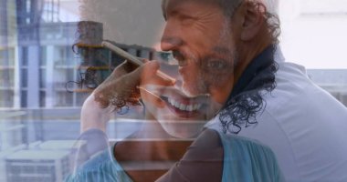 Turkuazlı gülümseyen kadın çatıdaki balkonda parmaklıklı ve erkek kaplamalı akıllı telefonla konuşuyor. Kentsel, iletişim, teknoloji, yaşam tarzı, modern, samimi, canlı