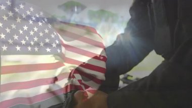 El sallayan bayrak, erkeğin bagaja uzanması, eldiven alması ve hazır olmak için kayışları bağlaması. Vatanseverlik, güvenlik, hazırlık, açık hava, maceracı, dayanıklı, taktik