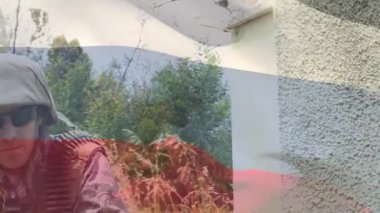 Asker binadan çıkıyor ve kemerle beslenmiş tüfekle etrafı tarıyor. Çevre güvenliğini sağlıyor. Ordu, keşif, kamuflaj, taktik, açık hava, güvenlik, engebeli