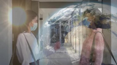 Dönen dünya koridoru kaplamaya başladığında, iki kadın dirsek tokuşturma selamı için yaklaşıyor. Küresel, birlik, işbirliği, çeşitlilik, bağlantı, arkadaşlık, modern