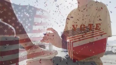 Diz çökmüş spor ayakkabısı bağlayan adam konfeti oylarını ateşliyor nabzı atıyor, el sıkışıyor, oylamayı destekliyor. Vatanseverlik, birlik, kutlama, çeşitlilik, açık hava, gündelik, arkadaşlık