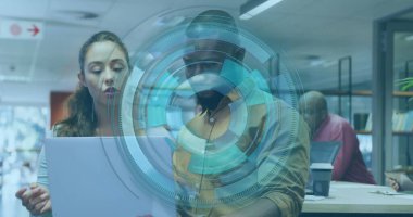 Modern ofisteki gümüş dizüstü bilgisayarda işbirliği yapan inceleme ekibi arayüz grafiğini sunuyor. İşbirliği, beyin fırtınası, yenilik, takım çalışması, dijital, profesyonel, çağdaş