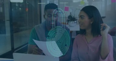 Pembe bluzlu iş arkadaşları ve deniz mavisi üstleri ofiste dijital güvenlik kaplamalı dokümanları inceliyor. İş, işbirliği, teknoloji, güvenlik, yenilik, çalışma alanı, profesyonellik