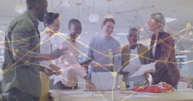 Ofisteki masanın etrafında çizelgeler ve spor ayakkabılarla işbirliği yapan altı profesyonel ofis çalışanı. İşbirliği, takım çalışması, modern ofis, veri görselleştirme, yaratıcı çalışma alanı, iş stratejisi, profesyonel kalkınma