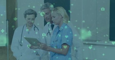 Hemşire elinde tablet tutarken meslektaşları hasta verilerini incelerken yüzen tıbbi ikonlar oluşturuyor. Sağlık, takım çalışması, dijital, işbirliği, hastane, teknoloji, profesyonellik