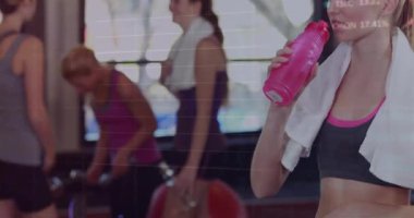 Jimnastik grubu halterleri bitirirken kadınlar da spor salonundaki veri hatları arasında su içmek için şişe kaldırıyor. Fitness, egzersiz, aktif, sağlık, eğitim, dayanıklılık, motivasyon