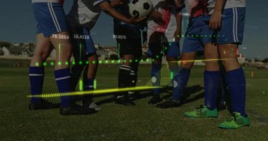 Altı futbolcu maç öncesi toplanıyor, el ele tutuşuyor, top üzerinde tezahürat yapıyor, top kaldırıyor. Sporcular, takım çalışması, kararlılık, spor giyim, rekabet, açık hava, sinerji