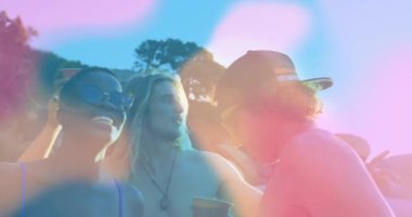 Arkadaşlar müzik eşliğinde sallanıyorlar, seyahat pazarlaması için sahile kırmızı bardakları kaldırıyorlar, merceklerde kaymalar oluyor. Kutlama, yoldaşlık, eğlence, canlı, açık hava, arkadaşlık, günbatımı.