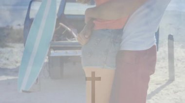 Adam kumsalda sörf tahtası ile kadının kollarına sarılıyor, tatilini kutlarken ona sarılıyor. Romantizm, açık hava, macera, güneşli, neşeli, yaşam tarzı