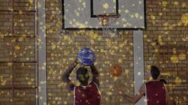 Mavi topu kavrayan oyuncu, duruşu düşürüyor ve basket taliminde çemberin altından atlıyor. Eylem, spor, atletizm, takım çalışması, rekabet, eğitim, mahkeme