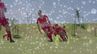 İlk oyuncu külahtan koşmaya başlıyor, takım külahların etrafında zikzak çiziyor futbol çevikliği eğitiminde koşuyor. Atletik, takım çalışması, hareket, spor, açık hava, dinamik, dinamik