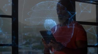 Teknoloji uzmanı tableti pencerelerden kaldırıyor ve ağ hatlarıyla holografik dünyayı döndürüyor. Gelecekçi, yenilikçi, bağlantı, dijital, teknoloji, profesyonel, modern