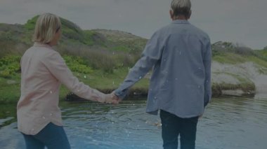 Bir çift sığ gölete adım atıp köpekleri izleyerek sağlığını gösterirken dalgalanmalar yaratıyor. Romantizm, sükunet, doğa, eğlence, uyum, sükunet, açık hava