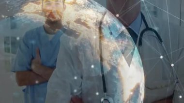 Tıbbi personelin üzerinde, küresel bakım verilerini birbirine bağlayan dönen ağ düğümlerini gösteren dijital bir küre var. Küresel, bağlantı, işbirliği, yenilik, teknoloji, sağlık hizmetleri, modern