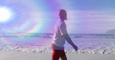 Adamın biri çerçeveye giriyor ve gökkuşağı merceğinin altındaki dalgalarla kıyı şeridinde geziniyor. Bu da sağlığı cesaretlendiriyor. Deniz kıyısı, sükunet, dinginlik, macera, açık hava, manzara, canlılık