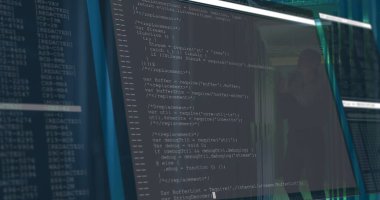 Ofis monitörü JavaScript kodunu cam bölme yansıması ile loş ışıklandırılmış çalışma istasyonunda gösteriyor. Teknoloji, programlama, yazılım geliştirme, kod, dijital ortam, profesyonel, modern