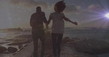 Erkek ve kadın gün batımında iskelede kameraya doğru koşuyor, seyahat reklamları için martıları kovalıyorlar. Romantizm, macera, sükunet, siluet, sahil, keşif, altın saat