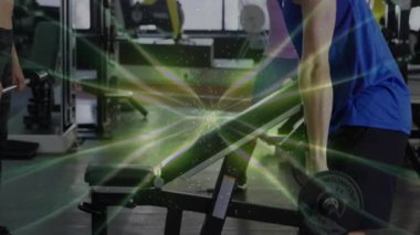 Spor salonundaki dambılları kaldıran adam, eğik basınca kadın üstten baskı yapıyor. Spor, spor, spor, spor, kararlılık, fonksiyonel