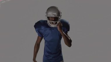 Futbolcu, fırlatmaya hazırlanırken yüz korumasına el kaldırıyor ve teknolojik verileri yoğunlaştırıyor. Sporcu, sporcu, gelecekçi, dijital, taktik, hareket, güç