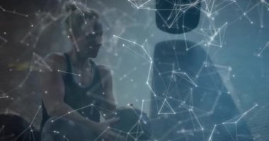 Bir kadın sağlık topuna uzanıyor, beden eğitimi dersinde gövdesini döndürüyor ve geometrik kaplama uyguluyor. Spor, güç, egzersiz, zindelik, eğitim, sağlık